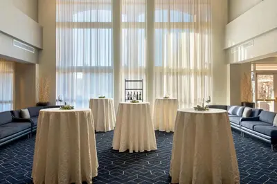 a room with two tables with white table cloths at Courtyard by Marriott Basking Ridge in Basking Ridge
