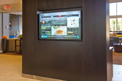 a flat screen tv on a wall in a lobby at Courtyard by Marriott Basking Ridge in Basking Ridge