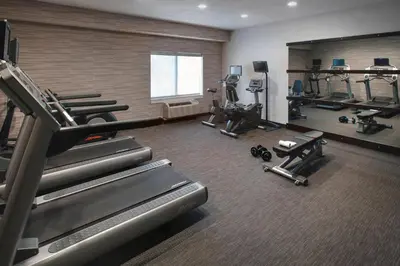 a gym with treadmills and machines in a room at Courtyard by Marriott Lebanon in Lebanon