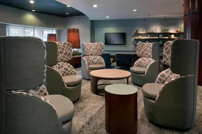 a waiting room with chairs and a table and a tv at Courtyard by Marriott Lebanon in Lebanon