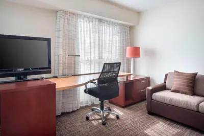 a hotel room with a desk with a television and a chair at Residence Inn Cranbury South Brunswick in Cranbury
