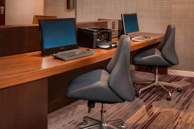 an office with a desk with a laptop and two chairs at Courtyard Wilmington Downtown in Wilmington