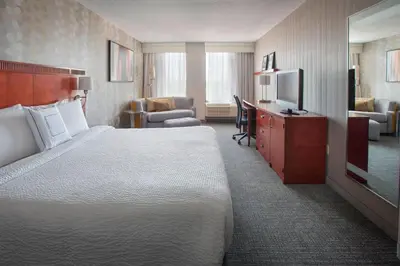 a hotel room with a bed and a flat screen tv at Courtyard Wilmington Downtown in Wilmington