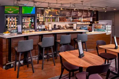 a bar in a restaurant with chairs and tables at Courtyard Wilmington Downtown in Wilmington