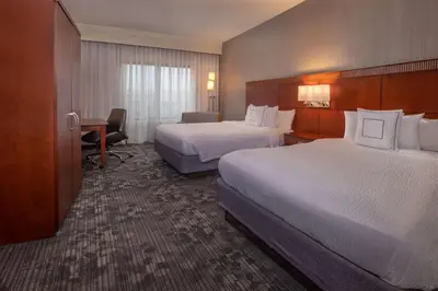 a hotel room with two beds and a desk at Sonesta Select Newark Christiana Mall in Newark