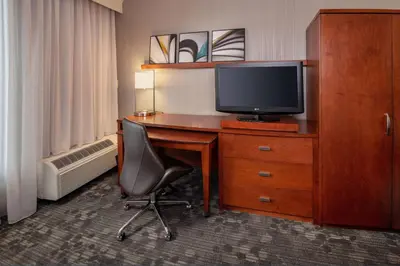 a hotel room with a desk with a tv and a chair at Sonesta Select Newark Christiana Mall in Newark