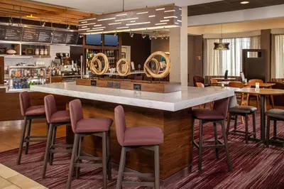 a bar in a restaurant with purple stools at Sonesta Select Newark Christiana Mall in Newark
