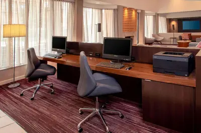 a room with a desk with two monitors and two chairs at Sonesta Select Newark Christiana Mall in Newark