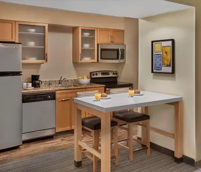 a kitchen with a table with two bar stools at Sonesta ES Suites Wilmington - Newark in Newark