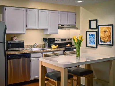 a kitchen with white cabinets and a counter with yellow flowers at Sonesta ES Suites Wilmington - Newark in Newark