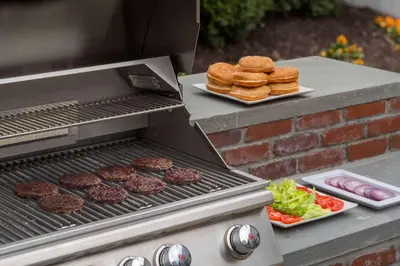 a grill with hamburgers and burgers and a plate of food at Sonesta ES Suites Wilmington - Newark in Newark