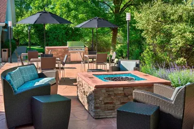 a patio with a fire pit and chairs and umbrellas at Residence Inn Philadelphia Valley Forge in Berwyn