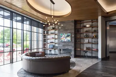 a living room with a large couch and a fireplace at Archer Hotel Florham Park in Florham Park