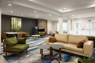 a lobby with a couch and chairs and tables at Fairfield Inn & Suites by Marriott Newark Liberty International Airport in Newark