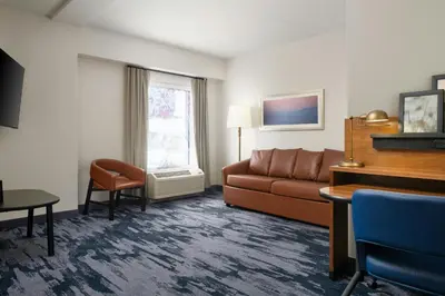 a living room with a couch and a table at Fairfield Inn & Suites by Marriott Newark Liberty International Airport in Newark