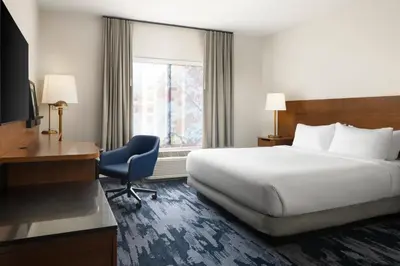 a hotel room with a bed and a desk and a window at Fairfield Inn & Suites by Marriott Newark Liberty International Airport in Newark