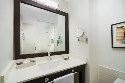 a bathroom with a sink and a large mirror at Courtyard New York Manhattan/Times Square in New York