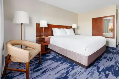 a hotel room with a bed and a chair at Fairfield Inn Philadelphia Airport in Philadelphia