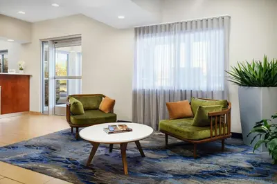 a living room with two chairs and a coffee table at Fairfield Inn Philadelphia Airport in Philadelphia