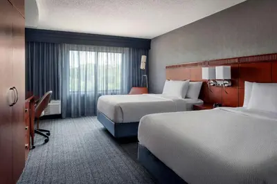 a hotel room with two beds and a window at Courtyard by Marriott Paramus in Paramus