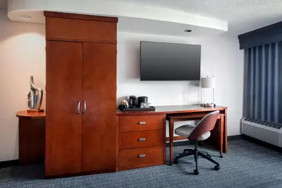 a hotel room with a desk and a tv and a chair at Courtyard by Marriott Paramus in Paramus