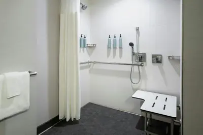 a bathroom with a shower and a bench in it at Courtyard by Marriott Paramus in Paramus