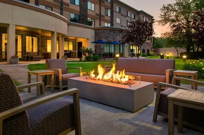 a fire pit in a patio with chairs and a building at Courtyard by Marriott Paramus in Paramus