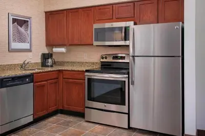 a kitchen with stainless steel appliances and wooden cabinets at Residence Inn by Marriott Newark Elizabeth/Liberty International Airport in Elizabeth