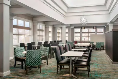 a dining room with tables and chairs and windows at Residence Inn by Marriott Newark Elizabeth/Liberty International Airport in Elizabeth