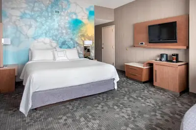 a hotel room with a large bed and a flat screen tv at Courtyard by Marriott Newark Elizabeth in Elizabeth