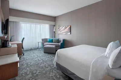 a hotel room with a bed and a chair at Courtyard by Marriott Newark Elizabeth in Elizabeth