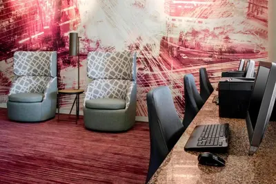 an office with two chairs and a desk with a computer at Courtyard by Marriott Newark Elizabeth in Elizabeth