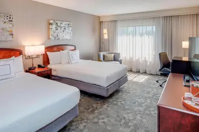 a hotel room with two beds and a television at Courtyard by Marriot Cranbury South Brunswick in Cranbury