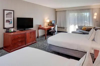 a hotel room with a bed and a flat screen tv at Courtyard by Marriot Cranbury South Brunswick in Cranbury