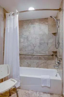 a bathroom with a white tub and a shower at Courtyard by Marriot Cranbury South Brunswick in Cranbury