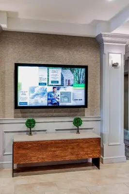 a flat screen tv on a wall in a lobby at Courtyard by Marriot Cranbury South Brunswick in Cranbury