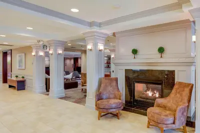 a living room with two chairs and a fireplace at Courtyard by Marriot Cranbury South Brunswick in Cranbury