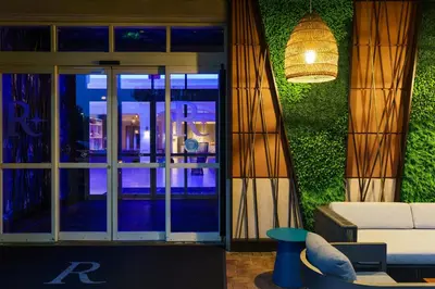 a living room with a couch and a glass door at Renaissance Meadowlands Hotel in Rutherford