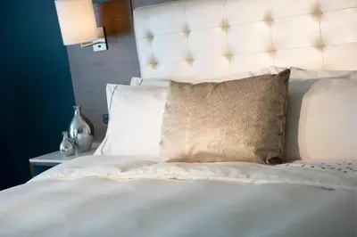a white bed with a white headboard and a pillow at Renaissance Meadowlands Hotel in Rutherford