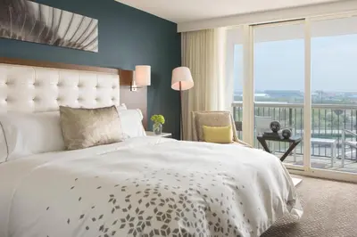 a bedroom with a large bed and a balcony at Renaissance Meadowlands Hotel in Rutherford