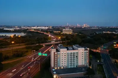 a tall white building next to a highway at night at Renaissance Meadowlands Hotel in Rutherford
