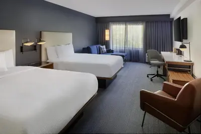 a hotel room with two beds and a desk at Courtyard Edison Woodbridge in Edison