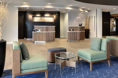 a lobby with two chairs and a table and a salon at Courtyard Edison Woodbridge in Edison