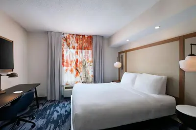 a hotel room with a bed and a desk and a window at Fairfield Inn & Suites by Marriott Edison - South Plainfield in Edison