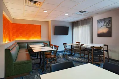 a restaurant with tables and chairs and a tv at Fairfield Inn & Suites by Marriott Edison - South Plainfield in Edison