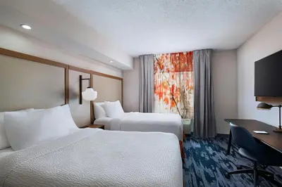 a hotel room with two beds and a desk at Fairfield Inn & Suites by Marriott Edison - South Plainfield in Edison