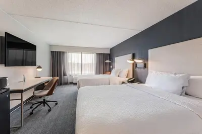 a hotel room with two beds and a desk at Courtyard Rockaway-Mount Arlington in Mount Arlington