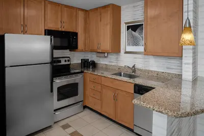 a kitchen with wooden cabinets and a white refrigerator at Residence Inn East Rutherford Meadowlands in East Rutherford