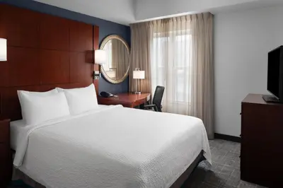 a hotel room with a bed and a desk and a mirror at Residence Inn East Rutherford Meadowlands in East Rutherford