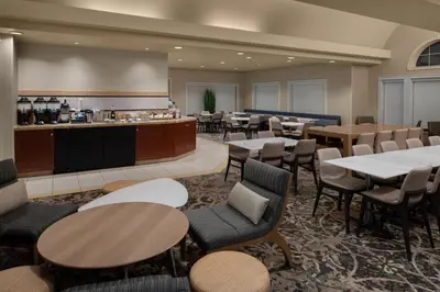a restaurant with tables and chairs and a bar at Residence Inn East Rutherford Meadowlands in East Rutherford